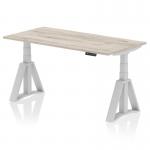 A modern office desk with a grey oak top and silver leg, featuring adjustable height options and a unique Piste Foot design. The sleek and dynamic design is perfect for any workspace.