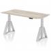 A modern office desk with a grey oak top and silver leg, featuring adjustable height options and a unique Piste Foot design. The sleek and dynamic design is perfect for any workspace.