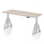 This image features a sleek grey oak top with silver legs and a piste foot, showcasing a dynamic sit stand and height adjustable office desk. The surface is 1800 x 800mm and offers versatile positioning options for optimal ergonomic support.