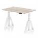 This photo features a sleek and modern office desk with a grey oak top and white legs. The desk is 1200 x 800mm and is height adjustable, allowing for dynamic sit and stand options. It also includes cable ports and a piste foot for added convenience.