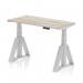 This photograph showcases a modern office desk with a sleek grey oak top and a height adjustable feature. The silver leg and piste foot add a touch of elegance, while cable ports ensure a clutter-free workspace. The desk measures 1200 x 600mm and features a dynamic sit stand option, making it perfect for a versatile and productive work environment.
