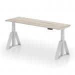 The photo shows a sleek, modern office desk with a grey oak top and silver legs. It features adjustable height and a convenient cable port for organization. The unique Piste Foot design makes this desk both stylish and functional. Perfect for creating a versatile and ergonomic workspace.