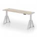 The photo shows a sleek, modern office desk with a grey oak top and silver legs. It features adjustable height and a convenient cable port for organization. The unique Piste Foot design makes this desk both stylish and functional. Perfect for creating a versatile and ergonomic workspace.