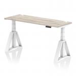 This image features a sleek grey oak top office desk with a white leg and piste foot, designed with cable ports for practicality. The desk is 1600 x 600mm and can be easily adjusted for sitting or standing positions, promoting a dynamic and ergonomic work environment.