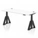 This photo features a sleek 1800 x 800mm white top desk with black legs and a Piste Foot, designed for height adjustability and improved ergonomics in the office. Cable ports can be seen on the surface for easy organization.
