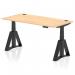 This image shows a modern office desk with a stylish maple top and black legs. It is 1600 x 800mm in size and features a dynamic sit-stand design with height adjustability. The desk also has built-in cable ports and a piste foot for added convenience and functionality.