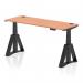 The image shows a modern and versatile Dynamic Sit Stand and Height Adjustable Desk. The desk features a sleek Beech top with built-in cable ports and is supported by a sturdy black leg with a Piste foot for added stability. The desks dimensions are 1600 x 600mm, making it suitable for a variety of office spaces.