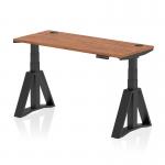 The picture shows a sleek black desk with a walnut top. It has a dynamic sit-stand feature and is height adjustable up to 1400 x 600mm. The desk also has cable ports and a stylish piste foot on the black legs.