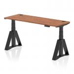 This image features a sleek and modern 1600 x 600mm walnut top office desk with black legs and a piste foot. The desk is height adjustable, perfect for those who prefer the option of sitting or standing while working. It also includes cable ports for easy organization and a dynamic sit stand feature.