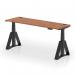 This photo captures a sleek, modern office desk with a walnut top and black leg. The desk is adjustable in height and features cable ports and a unique piste foot design. Its a perfect blend of style and functionality for any dynamic workspace.