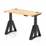 The photograph shows a spacious air 1200 x 600mm office desk in maple top with black legs. It features a dynamic sit stand and height adjustable design with cable ports and a piste foot for added functionality.
