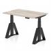 The photograph shows a sleek, modern office desk measuring 1200 x 800mm with a grey oak top and black legs. It features a dynamic sit stand option and is height adjustable to accommodate various working styles. The desk is also equipped with a piste foot for added stability.