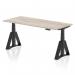 This photo shows a modern and versatile workspace with a sleek grey oak top and black adjustable legs. The desk can be raised or lowered to different heights, promoting a healthier work environment. The addition of a piste foot adds stability and style to the overall design.