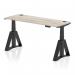 This image shows a sleek, modern office desk with a grey oak top and black legs. It features a dynamic sit stand design and is adjustable in height from 600mm to 1600mm. The desk also has convenient cable ports and a unique piste foot for added stability.