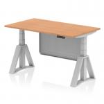 The picture shows a sleek and modern workspace, featuring a 1400 x 800mm oak top desk with silver legs. The desk is height adjustable and also equipped with a dynamic sit-stand function. A silver steel modesty panel adds a touch of elegance, while the piste foot provides stability.