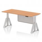 The photo shows a sleek and modern 1800 x 800mm height adjustable office desk. It features an oak top and silver leg, along with a silver steel modesty panel and piste foot. The desk is designed to promote a dynamic work style with its sit-stand capabilities.