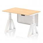 The photo captures a sleek Dynamic Sit Stand desk with a 1200 x 800mm maple top, white steel legs, and a white steel modesty panel. The desk also features height adjustability and a piste foot for added support.