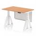 This photograph features a modern office setup with a Dynamic Sit Stand and Height Adjustable Desk. The desk measures 1200 x 800mm and has an oak top and a white leg. There is also a white steel modesty panel and a piste foot visible.