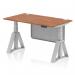This picture shows a sleek and modern office desk with a walnut top and silver legs. The desk is adjustable in height and features cable ports for organization. A silver steel modesty panel and piste foot add to the functionality of the desk.