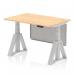 This photograph features a modern, sleek office desk with a maple top and silver legs. It has cable ports for easy organization and a steel modesty panel with a piste foot for added stability. The desk is height adjustable, allowing for a dynamic sit-stand work style.