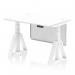 This photograph shows a white top office desk, 1200 x 800mm in size, with adjustable height and a dynamic sit-stand feature. The desk also has cable ports, a white steel modesty panel, and a piste foot for added stability.
