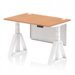 This photo features a modern office setup with a dynamic sit stand desk and height adjustable capabilities. The desk has an oak top with cable ports, white legs, and a white steel modesty panel. The piste foot adds a sleek touch to the overall design.