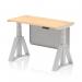 This photograph showcases a sleek and practical office space with a dynamic sit-stand desk. The 1200 x 600mm maple top is complemented by silver legs and a modesty panel, while a cable port and piste foot add functionality. The height adjustability allows for personalized comfort.