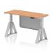 This picture features a sleek and modern height adjustable desk with an oak top and silver legs. The desk also has built-in cable ports and a modesty panel, with a piste foot for added stability. Perfect for creating a dynamic and ergonomic workspace.