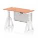 The photograph captures a modern and flexible workspace with a sleek height adjustable desk. The desk features a beech top with contrasting white legs and a steel modesty panel. Cable ports and a piste foot add practicality and style to this dynamic sit stand desk.