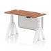 This photograph features a dynamic sit stand and height adjustable office desk with a walnut top and white legs. The desk measures 1200 x 600mm and includes cable ports and a white steel modesty panel with piste foot.