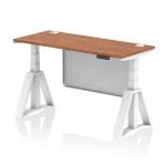 This picture shows a sleek and modern dynamic sit stand and height adjustable desk. The desk features a 1400 x 600mm walnut top with cable ports and a white steel modesty panel. The white legs and piste foot add a touch of elegance to the overall design. Perfect for any contemporary office space.