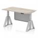 This image showcases a sleek grey oak top desk with a silver leg and steel modesty panel. It is height adjustable and features a piste foot for added stability. The desk also boasts a dynamic sit stand function, making it versatile for any office setting.