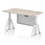 The photo shows a sleek grey oak top office desk with a white height adjustable leg, complete with a white steel modesty panel and piste foot. This dynamic sit stand desk allows for comfortable and customizable work positions. Modern and practical for any workspace.
