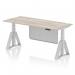 The image shows a sleek and modern 1800 x 800mm grey oak top desk with a silver leg and silver steel modesty panel. The desk is height adjustable, with cable ports for organization and a piste foot for stability. It exudes a sense of flexibility, style and versatility for any office setting.