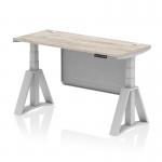 This picture features a sleek and modern Dynamic Sit Stand and Height Adjustable Desk. The desk measures 1400 x 600mm and has a Grey Oak top with cable ports. The legs are a striking silver color, as well as the steel modesty panel. The desk also includes a Piste Foot for extra stability.