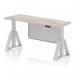 This image features a sleek grey oak top on a 1600 x 600mm height adjustable office desk, with a silver leg and modesty panel. The desk also includes cable ports for organization and a piste foot for added stability.