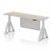This photo features a sleek and modern 1800 x 600mm height adjustable office desk in grey oak, with a silver leg and steel modesty panel. The desk also has cable ports and a piste foot for additional support. The adjustable design allows for a dynamic sit-stand experience.