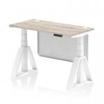The photograph shows a sleek and modern office desk with a grey oak top and white steel frame. It also features height adjustability, cable ports, and a white steel modesty panel. The unique piste foot design adds a touch of style and functionality. Perfect for a dynamic and ergonomic workspace.