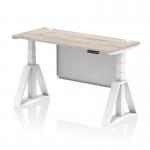 This picture features a sleek grey oak top on a white adjustable desk with cable ports and a steel modesty panel. The white legs and piste foot give it a modern and professional look.