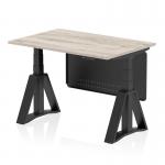This photo features a sleek, modern office desk with a grey oak top and black steel legs. The desk is equipped with a height adjustable mechanism, allowing users to switch between sitting and standing positions. It also has a black steel modesty panel and piste foot for added stability.