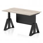 The picture shows a gray oak top with a black steel modesty panel on a dynamic sit stand and height adjustable desk. The desk measures 1400 x 800mm and has black legs with a piste foot for stability. It is suitable for use in offices and can be adjusted to different heights for comfort while working.