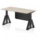This image shows a modern and sleek office desk with a grey oak top, black legs, and a black steel modesty panel. The desk is adjustable in height and features a piste foot for added support. It has a dynamic sit-stand design, promoting a healthy work environment.