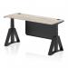 The image shows a sleek and modern office desk with a grey oak top, black legs, and a black steel modesty panel. The desk also features cable ports and a piste foot for stability. Its dynamic sit-stand and height adjustable design makes it suitable for various work preferences.