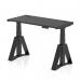 A photo of a Dynamic Sit Stand and Height Adjustable Desk in Black Top and Black Leg is shown. The desk measures 1200 x 600mm and has cable ports for easy organization. The design also features the Piste Foot for added support and stability. This desk offers a versatile and modern option for any office space.