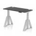 This picture shows a dynamic sit stand and height adjustable desk measuring 1200 x 600mm. The desk has a sleek black top and silver legs with a piste foot for stability. It also features convenient cable ports. The versatile design allows for both sitting and standing work positions.