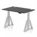 This picture shows a sleek and modern office desk with a black top and silver legs. It features cable ports for easy organization and a piste foot for added stability. The desk is also height adjustable, allowing for a dynamic sit or stand work experience.