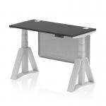 This picture shows a modern and versatile office desk with a black top and silver legs. The desk is 1200 x 600mm in size and features adjustable height and sit stand options. The sleek design is complemented by cable ports and a silver steel modesty panel. The desk also has a piste foot for added support and stability.