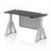 The photograph captures a sleek and modern office workspace with a dynamic sit stand and height adjustable desk. The desk features a black top with cable ports and a silver leg, complemented by a silver steel modesty panel and piste foot. The 1400 x 600mm desk is versatile and practical for any work environment.