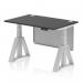 The picture shows a sleek Dynamic Sit Stand and Height Adjustable Desk with a 1200 x 800mm black top and silver legs. The desk also features cable ports, a silver steel modesty panel, and a piste foot for added stability. This desk is perfect for any modern office space.