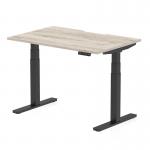 This photo shows a modern and versatile office desk, measuring 1200 x 800mm, with a scalloped edge for added style. The height adjustable feature allows for a dynamic sit-stand option, promoting a healthier work environment. The grey oak top and black leg give a sleek and professional look to any workspace.